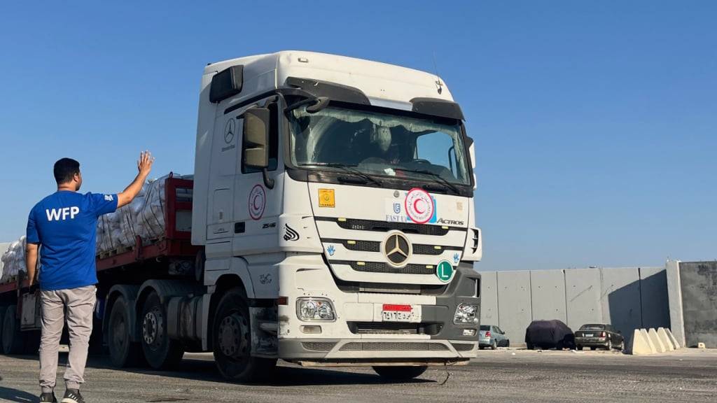 ARCHIV - Ein Mitarbeiter des Welternährungsprogramms begrüßt am Grenzübergang Rafah zwischen Ägypten und dem Gazastreifen einen Lastwagenfahrer, der humanitäre Hilfsgüter transportiert. Foto: Mohammed Arafat/AP/dpa