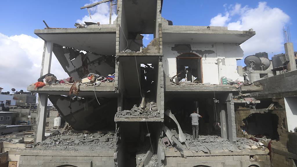 Palästinenser betrachten die Zerstörung nach einem israelischen Angriff auf ein Wohnhaus in Rafah im Gazastreifen. Foto: Ismael Abu Dayyah/AP