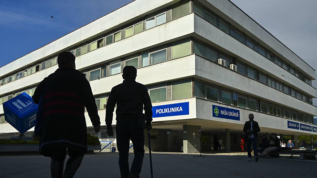 Menschen gehen am F. D. Roosevelt Universitätskrankenhaus vorbei, in dem der angeschossene und verletzte slowakische Premierminister Robert Fico behandelt wird. Foto: Denes Erdos/AP/dpa