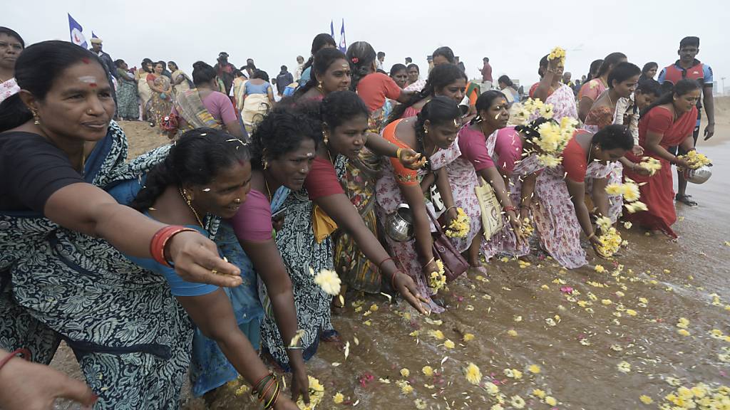 Menschen gedenken der Opfer des Tsunami von 2004 am 20. Jahrestag am Marina Beach. Ein Seebeben der Stärke 9,0 vor der indonesischen Insel Sumatra löste gewaltige Flutwellen - Tsunamis - aus, die die Küsten des Indischen Ozeans verwüsteten. Etwa 230.000 Menschen kamen ums Leben, darunter auch 552 Deutsche. Foto: Mahesh Kumar A./AP/dpa