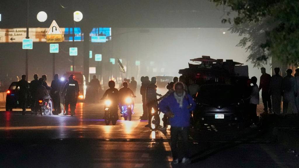 Pakistanische Polizeibeamte entfernen nach einem indischen Raketenangriff Fahrzeuge und Personen vom Haupteingang des Luftwaffenstützpunkts Nur Khan. Foto: Anjum Naveed/AP/dpa