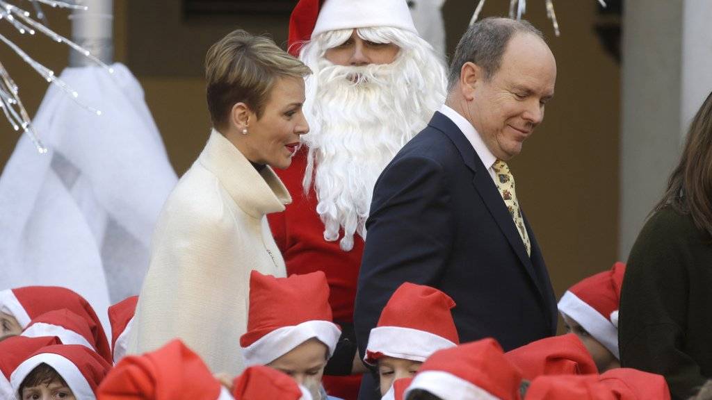 Ein royales Paar in Festtagsstimmung: Fürst Albert II. und seine Frau Charlène von Monaco, hier von kleinen und grossen Samichläusen umgeben, posierten für das offizielle Weihnachtsfoto vor einem Greifvogel (Archiv).