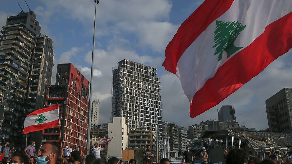 Regierungskritische Demonstranten nehmen an Demonstranten mit der Fahne des Libanon Mitte August bei einem Trauermarsch für die Opfer der verheerenden Explosion von Beirut. Foto: Marwan Naamani/dpa