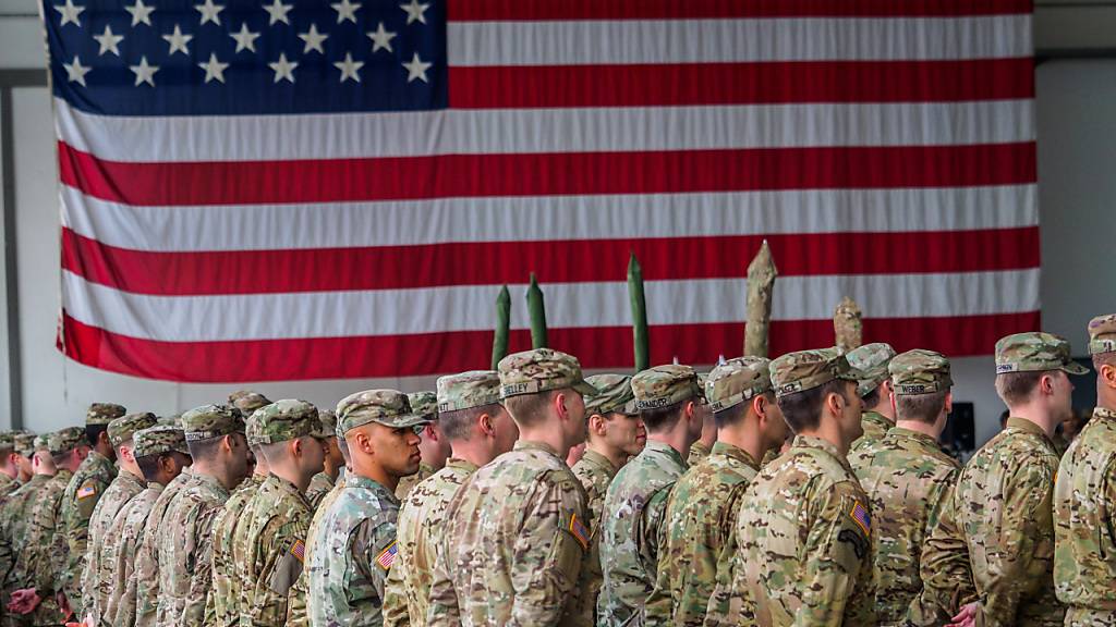 ARCHIV - US-Soldaten stehen während einer militärischen Zeremonie in Bayern vor einer Flagge der Vereinigten Staaten von Amerika. Foto: Nicolas Armer/dpa
