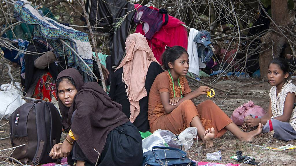 Geflüchtete Rohingya ruhen sich in der Nähe eines Strandes am Boden aus, nachdem ihre Boote an den Andamanen gestrandet war. Nach Monaten auf See sind Dutzende Flüchtlinge der muslimischen Minderheit der Rohingya aus Myanmar in Indonesien gelandet.