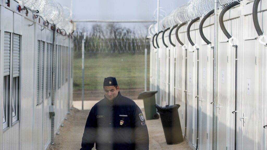 ARCHIV - Ein ungarischer Polizist patrouilliert durch das Internierungslager für Asylsuchende an der Grenze zu Serbien. Foto: Sandor Ujvari/MTI/AP/dpa