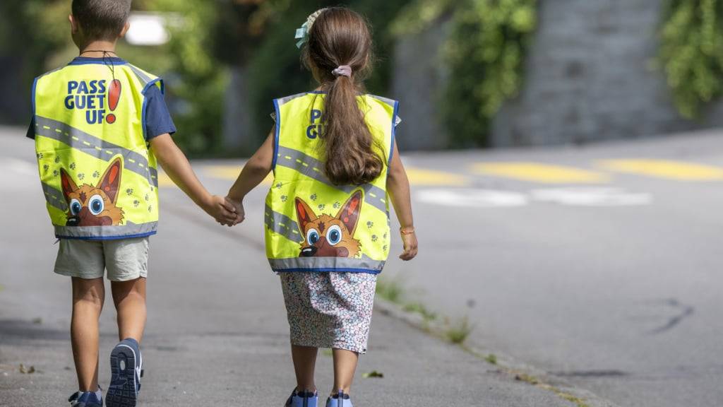 Kinder der 1. Klasse des Schulhauses Hofmatt in Horw LU  präsentieren zum Schulstart auf ihrem Schulweg ihre neue Leuchtweste.