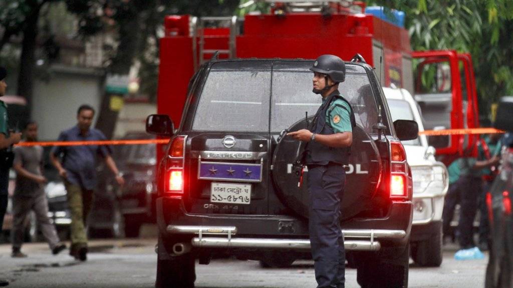 Polizisten riegeln das Gebiet ab, in dem der Angriff geschah - laut der Regierung gehörten die Angreifer auf ein Café in Dhaka einer lokalen Islamistenorganisation an.