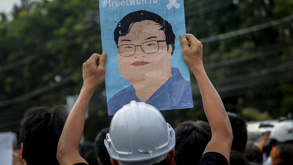 Ein Demonstrant in Bangkok zeigt ein Plakat mit einem Bild des kürzlich inhaftierten Protestführers Parit Chiwarak. Foto: Sakchai Lalit/AP/dpa