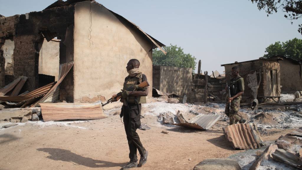 ARCHIV - Soldaten patrouillieren vor niedergebrannten Häusern, Tage nach einem Angriff in dem Dorf Woro. Bewaffnete haben bei einem Angriff in Nigeria Dutzende Menschen getötet. Foto: Pelumi Salako/AP/dpa