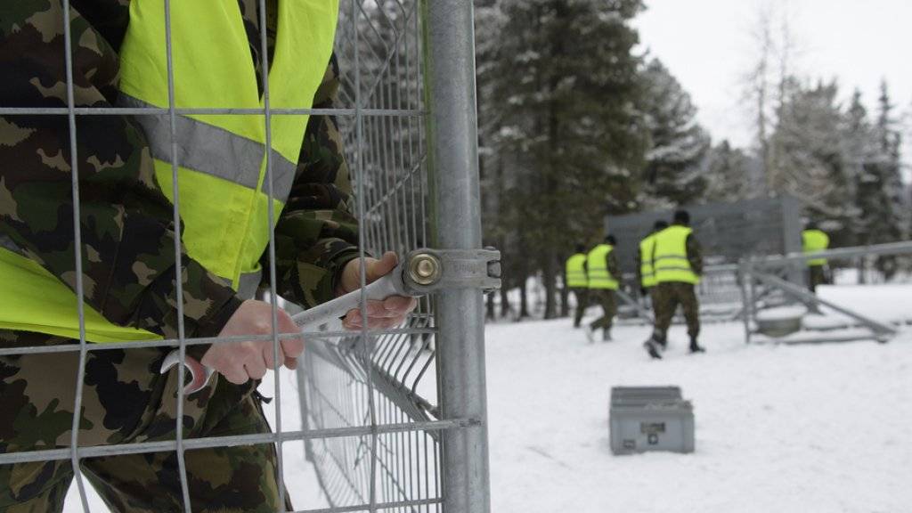 Angehörige der Schweizer Armee errichten im Kurpark des Davoser Kongresszentrums einen Zaun für das WEF.