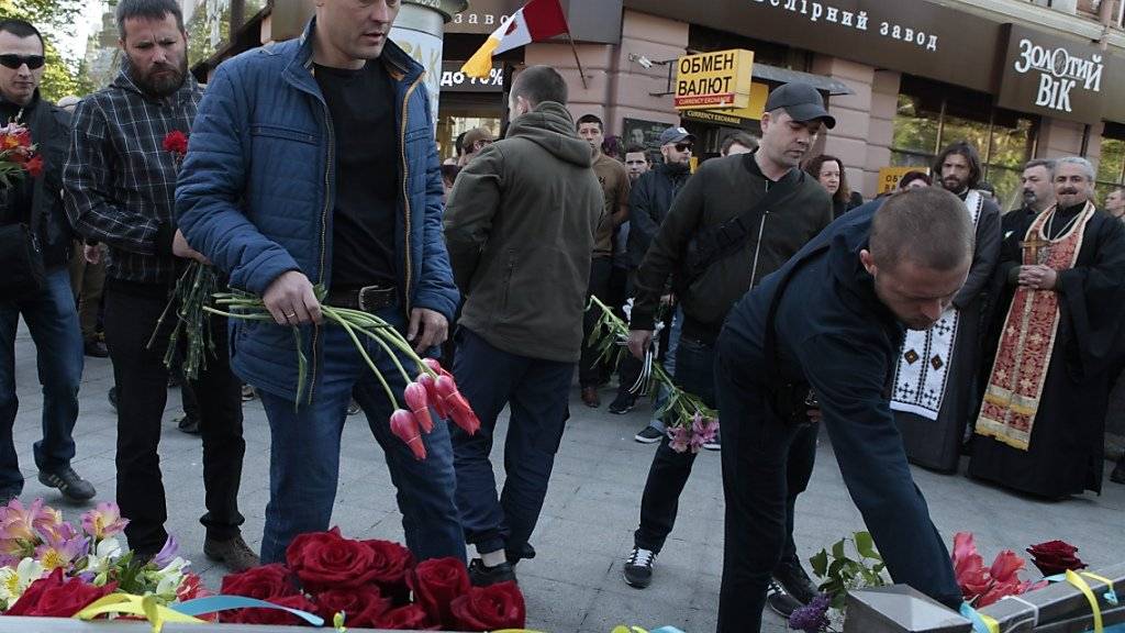 Fünf Jahre nach der Gewalteskalation in Odessa legen Menschen im Gedenken an die 48 Todesopfer Blumen vor dem Gewerkschaftshaus nieder.