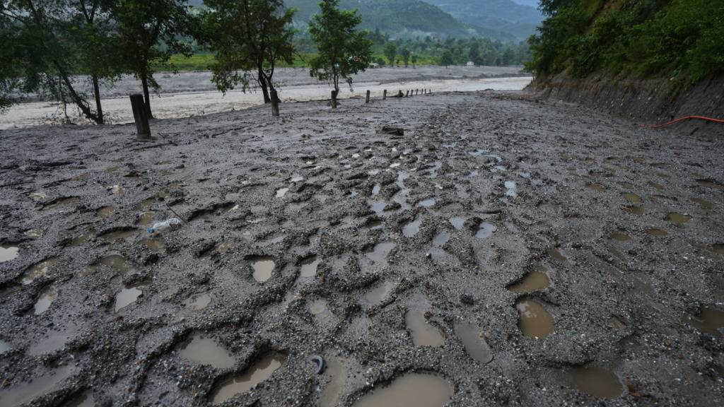 Am Ufer des angeschwollenen Flusses Trishuli sind nach Sturzfluten in Bidur im Distrikt Nuwakot Fußspuren von Rettungskräften zu sehen. Foto: Rajesh Kumar Singh/AP/dpa