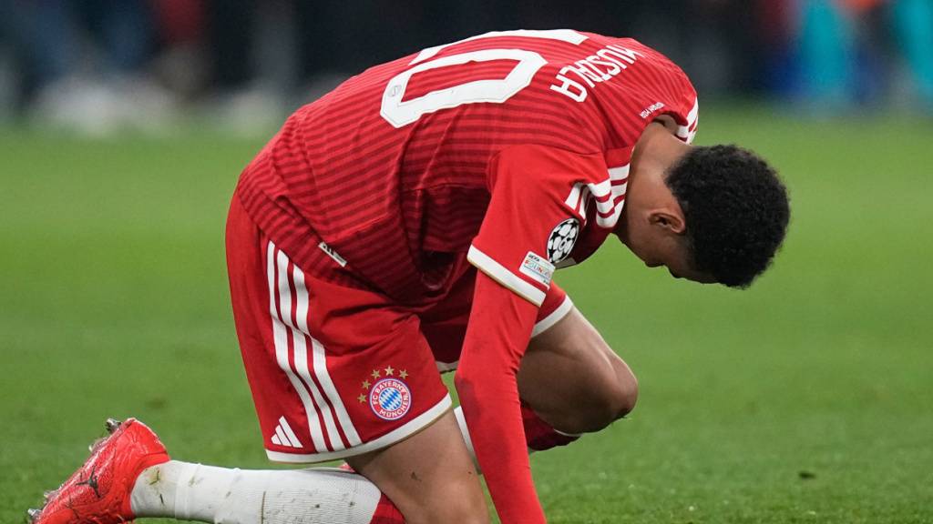 Bayern Münchens Offensivspieler Jamal Musiala kniet auf dem Rasen