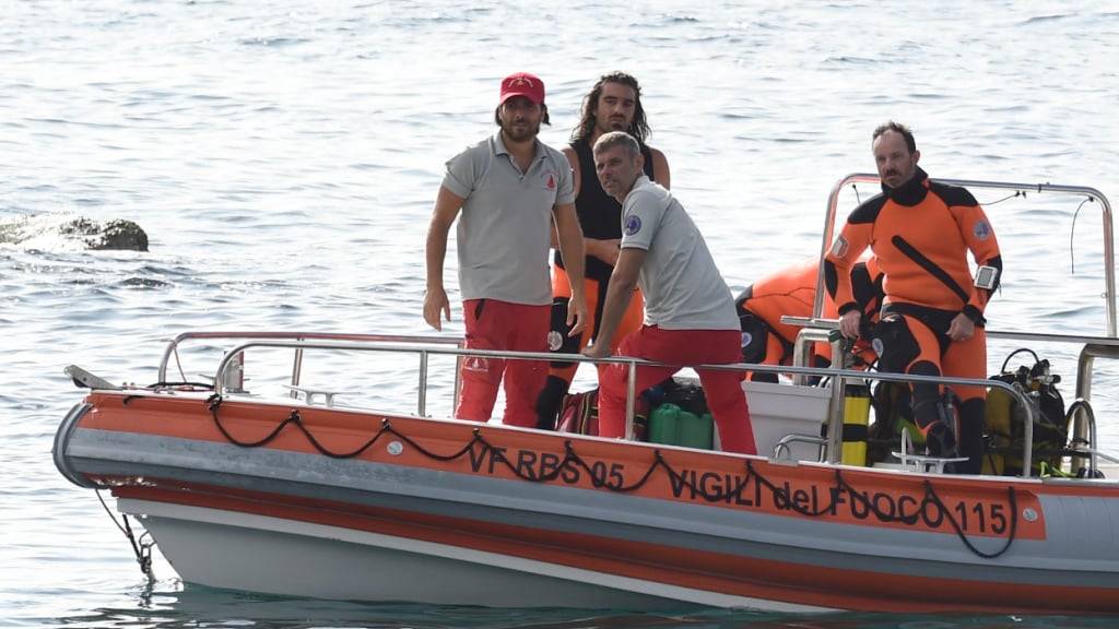 Italienische Einsatzkräfte kehren mit einem Rettungsboot in den Hafen zurück. Foto: Salvatore Cavalli/AP/dpa