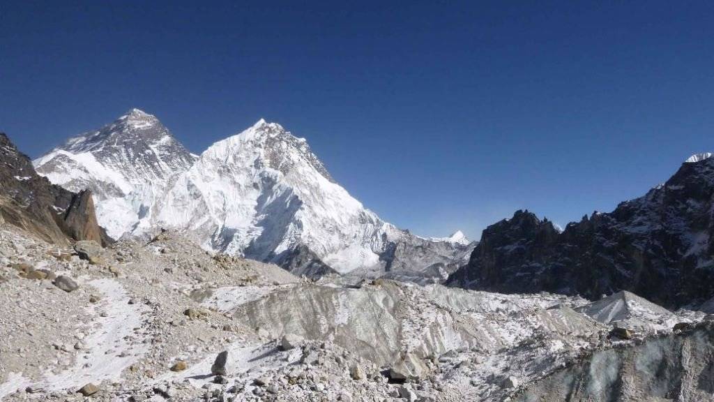 Blick auf den Mount Everest (links im Hintergrund). Im Vordergrund ist der Changri Nup, ein typischer, teils mit Geröll bedeckter Gletscher zu sehen.
