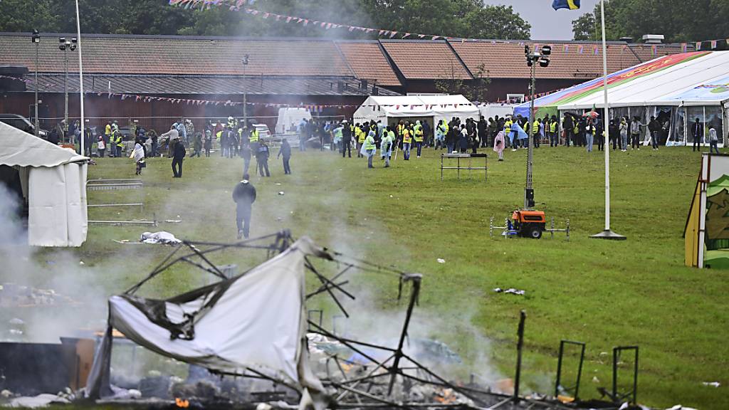 Rauch steigt aus einem niedergebrannten Zelt während des eritreischen Kulturfestivals «Eritrea Scandinavia». Foto: Magnus Lejhall/TT News Agency/AP/dpa