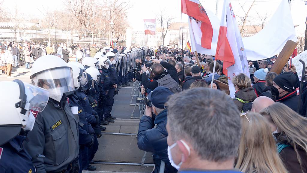 Demonstranten stehen bei einer Kundgebung gegen die Corona-Maßnahmen der österreichischen Bundesregierung einer Polizeilinie gegenüber. Foto: Herbert Pfarrhofer/APA/dpa