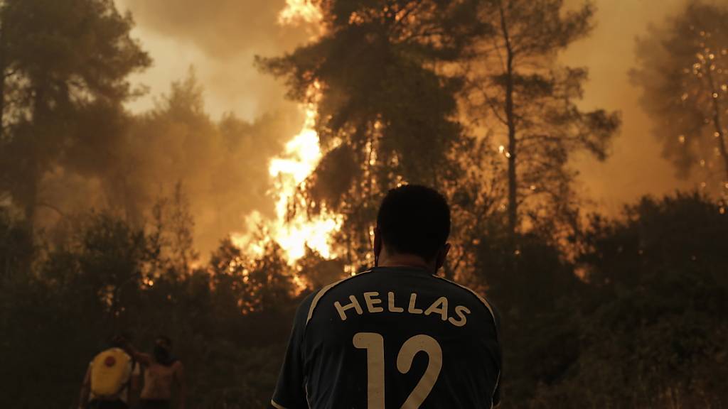 Einwohner und freiwillige Helfer kämpfen gegen einen Waldbrand in der Nähe von Pefki auf der Insel Euböa. Klimaextreme wie Hitzewellen und Starkregen seien jetzt in jeder Region der Welt zu beobachten, stellt der jüngste IPCC-Bericht fest.
