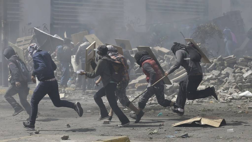 Protestierende Regierungsgegner flüchten am Samstag in Quito vor dem Tränengas der Polizei.