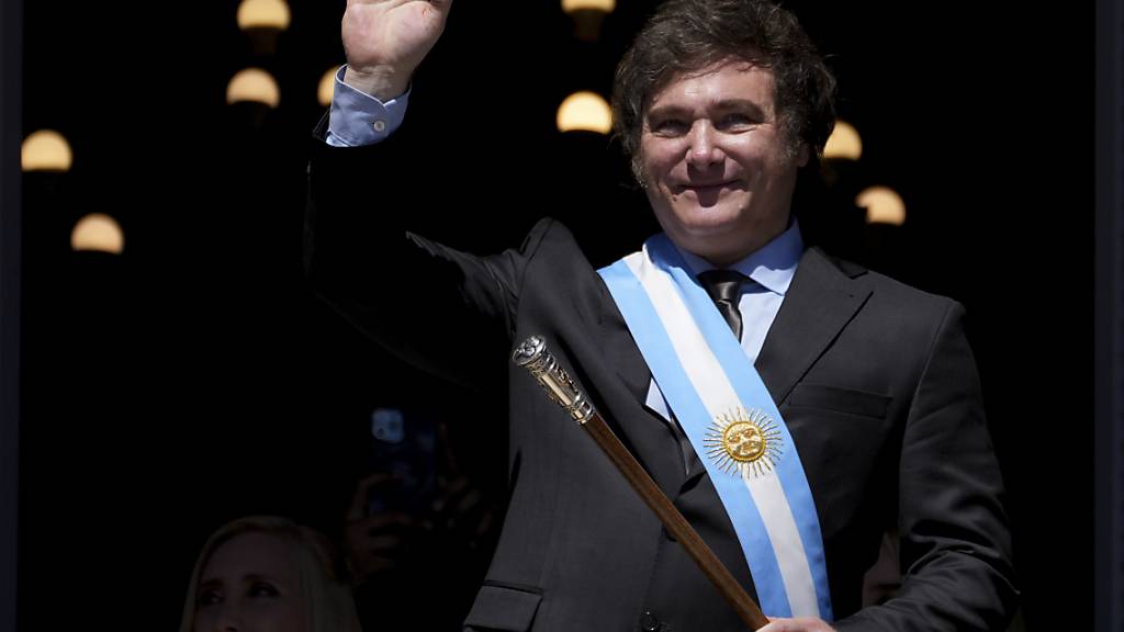 Argentiniens neuer Präsident Javier Milei winkt vom Balkon des Regierungsgebäudes zu seinen Anhängern. Foto: Matilde Campodonico/AP/dpa