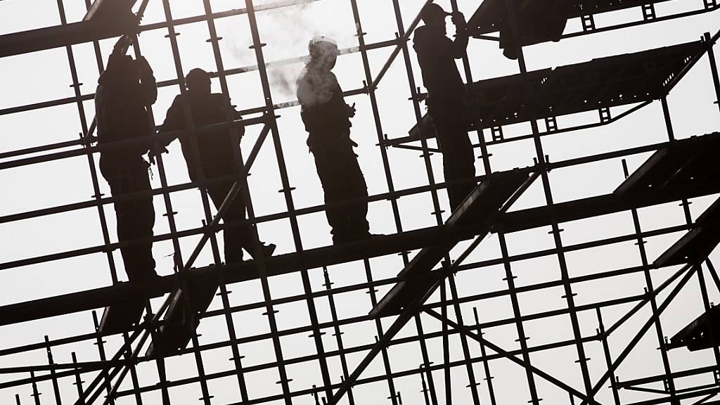 Arbeiter errichten in Hamburg auf einer Brückenbaustelle in der Hafencity ein Gerüst. (Archivbild)