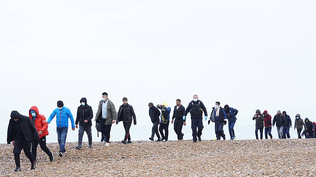 Mutmaßliche Migranten kommen an einem Strand an. Medienberichten zufolge will Großbritannien angesichts einer Rekordzahl illegal eingereister Migranten härtere Regeln für Asylsuchende einführen. Das geht aus einem Bericht der Zeitung «Telegraph» mit Bezug auf Innenministerin Priti Patel hervor. Foto: Gareth Fuller/PA Wire/dpa