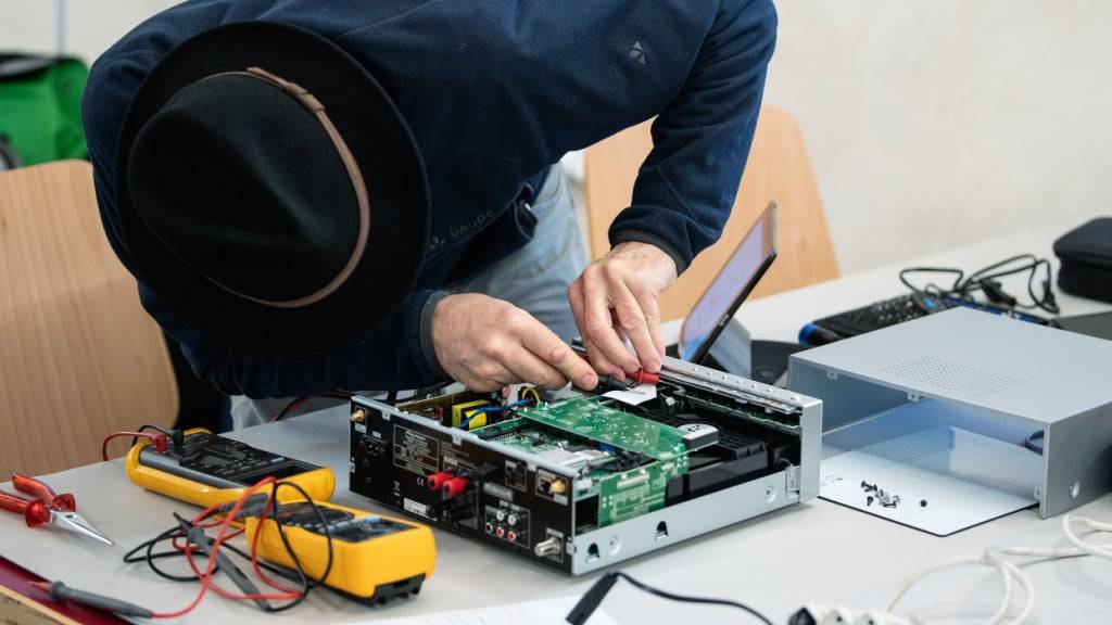 Ein Fachmann repariert 2022 einen CD-Player im Repair Café Herzogenbuchsee BE. (Archivbild)