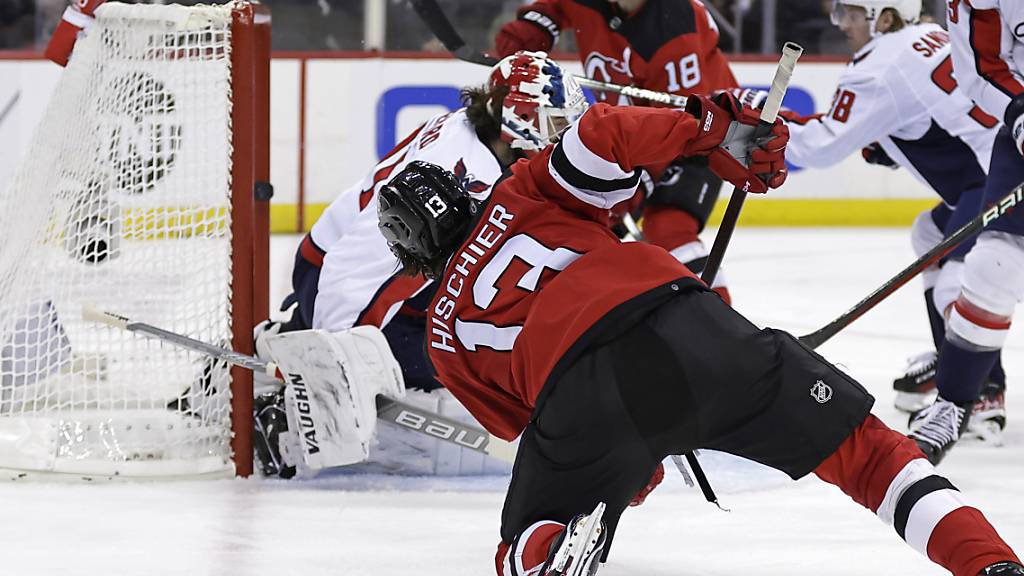 Auf den Knien bezwingt Devils-Captain Nico Hischier Washingtons Goalie Hunter Shepard