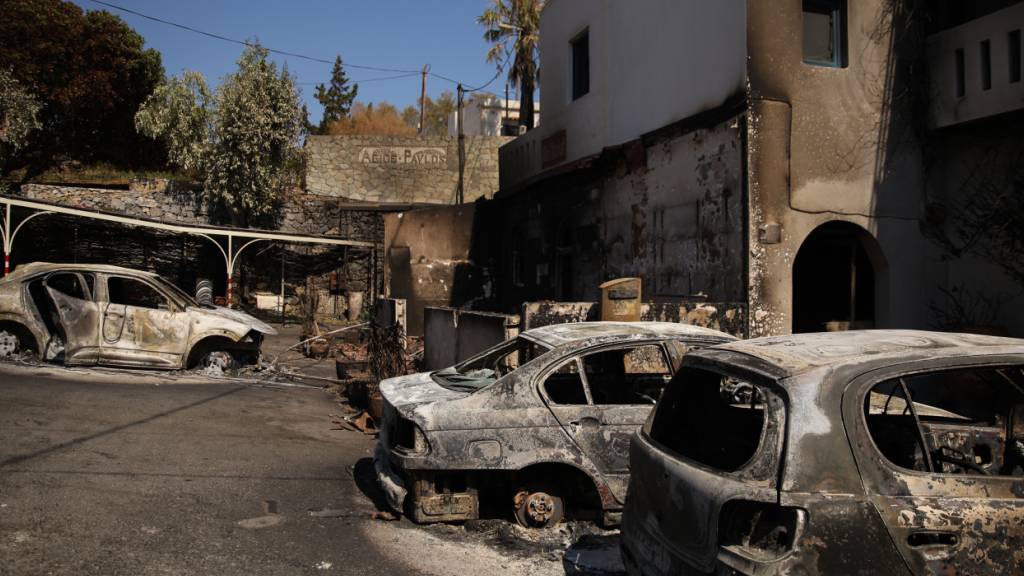 ARCHIV - Ausgebrannte Autos vor einem Hotel im Stadtteil St. Paul im Süden von Rethymno. Foto: Socrates Baltagiannis/dpa
