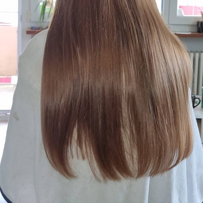 Jugileiterin schneidet Mädchen eine Haarsträhne ab