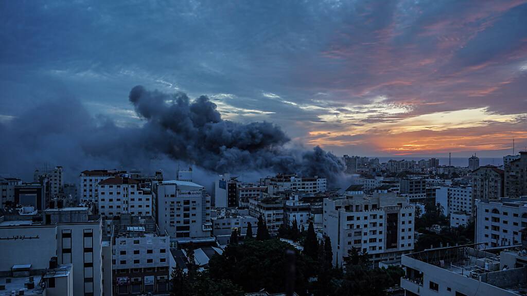 Rauch steigt vom «Palestine Tower» im Stadtteil Al-Rimal auf. Die islamistische Hamas hat einen großangelegten Überraschungsangriff auf Israel gestartet. Die EU, die USA und Israel stuft die Hamas als Terrororganisation ein. Das israelische Militär entgegnete mit dem Beschuss von Zielen der Hamas im Gazastreifen. Foto: Saher Alghorra/ZUMA Press Wire/dpa