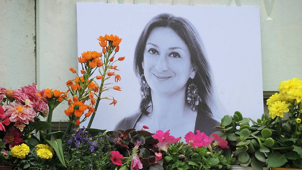 ARCHIV - Kerzen und Blumen stehen im Gedenken vor einem Foto der ermordeten maltesischen Journalistin Daphne Caruana Galizia vor dem Justizpalast. Foto: Lena Klimkeit/dpa