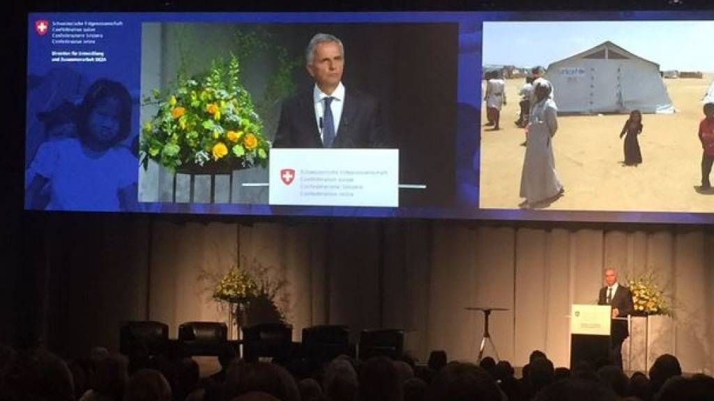 Bundesrat Didier Burkhalter an der Jahrestagung der Humanitären Hilfe, mit dem Foto eines Flüchtlingslagers