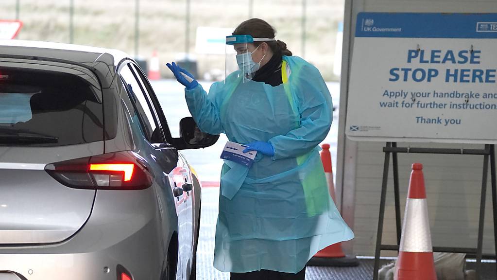 Eine Mitarbeiterin entnimmt einem Bürger eine Probe auf dem Corona-Testgelände am Flughafen Edinburgh. Foto: Andrew Milligan/PA Wire/dpa