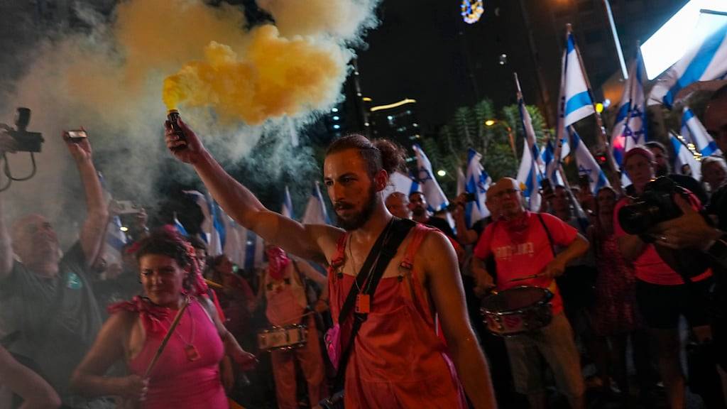 Israelis halten Pyrotechnik, während sie gegen die Justizreform des israelischen Premierministers Netanjahu protestieren. Foto: Tsafrir Abayov/AP/dpa