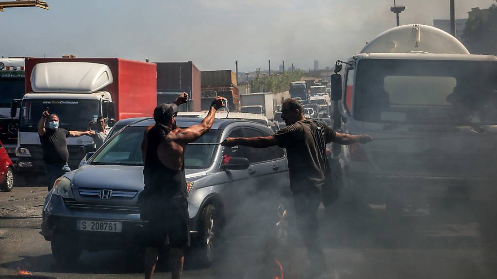 Demonstranten verhindern die Durchfahrt von Autos indem sie eine Hauptstraße mit brennenden Reifen blockieren. Die Demonstranten protestieren gegen die kollabierende Wirtschaft und den Lebensstandard im Libanon. Foto: Marwan Naamani/dpa