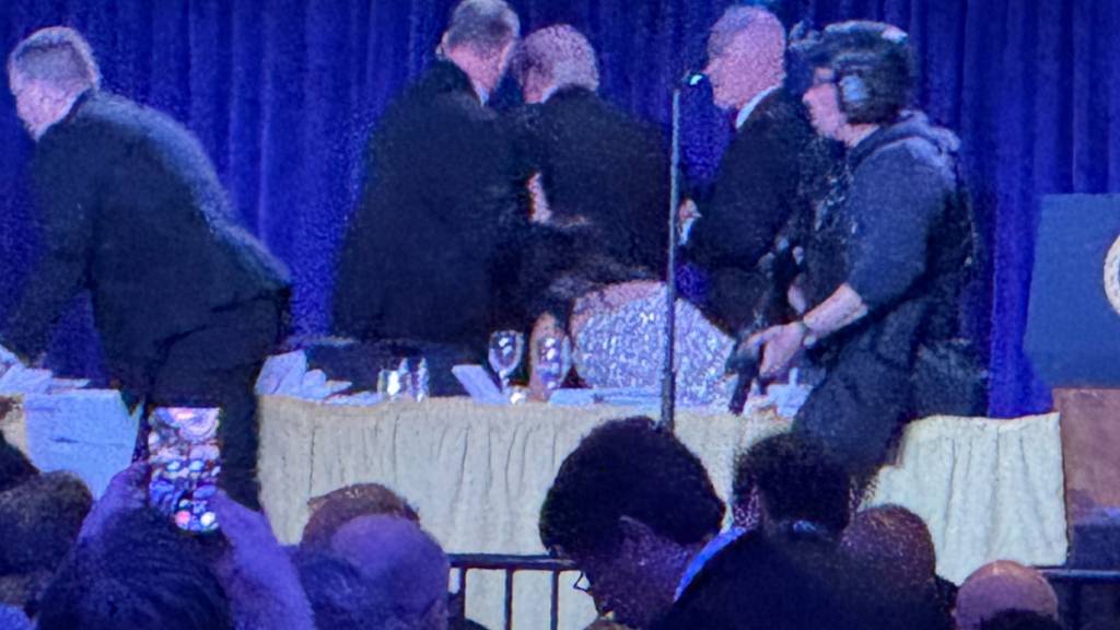 US-Geheimdienstmitarbeiter umringen US-Präsident Donald Trump nach den Schüssen während des White House Correspondents' Dinner. Foto: Mark Schiefelbein/AP/dpa