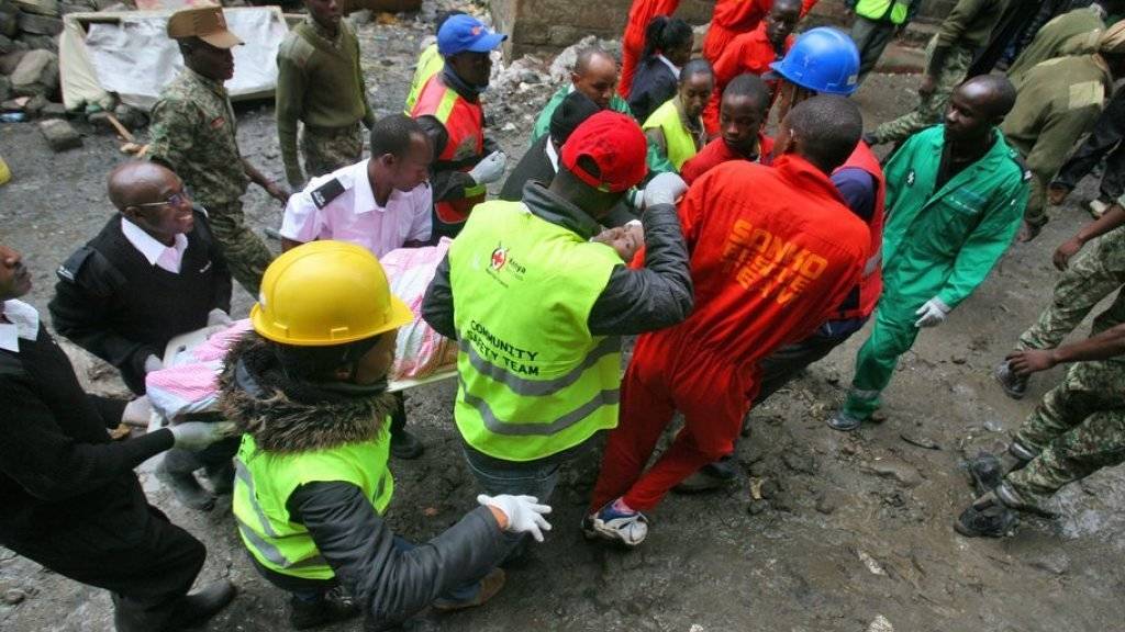 Rettungskräfte tragen einen Überlebenden des Hauseinsturzes in Nairobi auf einer Bahre. Mehr als 120 Menschen konnten gerettet werden, nach weiteren Menschen wurde gesucht.