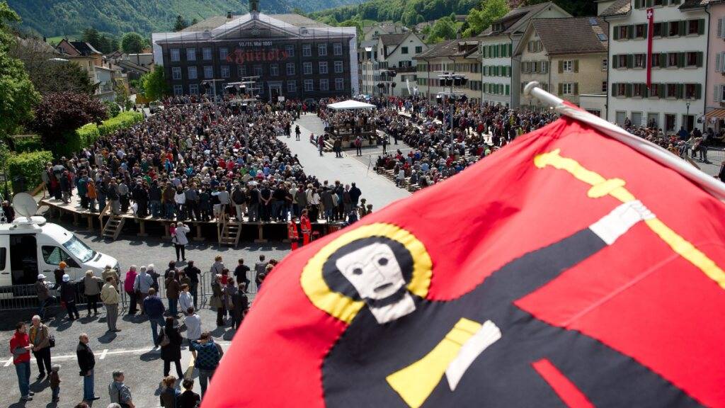 Der Landsgemeindeplatz in Glarus mit einer Fahne mit dem Glarner Patron Fridolin. Der Klostergründer aus dem Frühmittelalter gab nicht nur der Gratiszeitung «Fridolin» seinen Namen, sondern ziert auch Kantonsfahne und Kantonswappen. (Archivbild)
