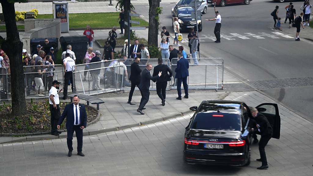 dpatopbilder - Leibwächter bringen den slowakischen Ministerpräsidenten Robert Fico in einem Auto vom Ort des Geschehens in Sicherheit. Fico war nach einer Kabinettssitzung in der Stadt Handlova angeschossen und verletzt worden. Foto: Radovan Stoklasa/TASR/dpa