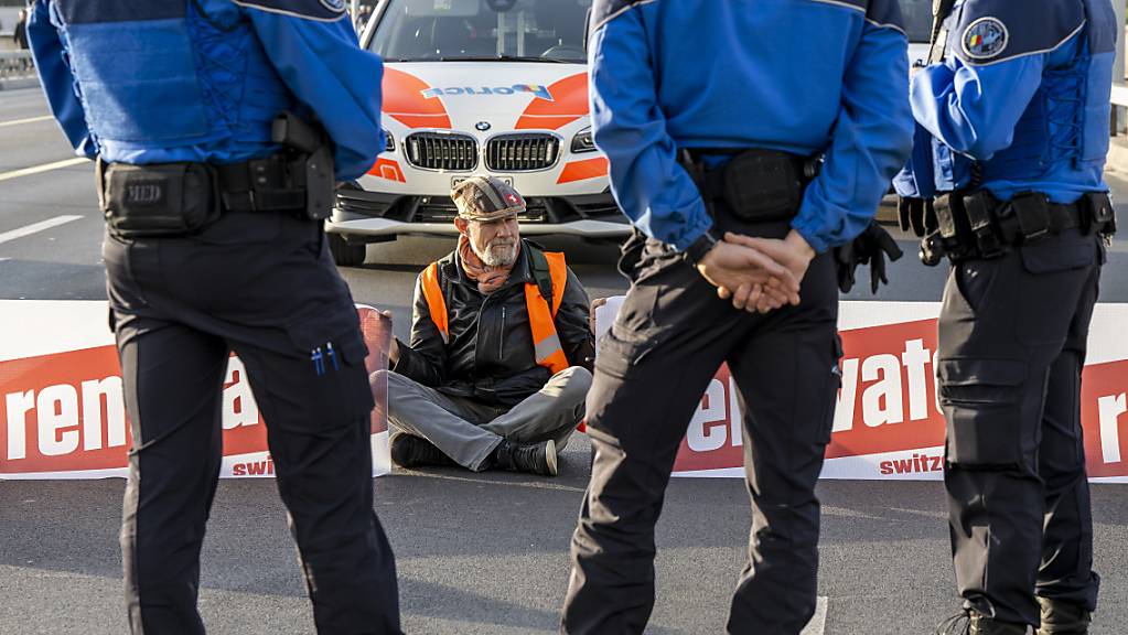 Die Genfer Polizei nimmt bei einer Protestaktion auf der Mont-Blanc-Brücke einen Klimaaktivisten fest.