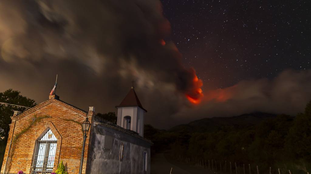 Rauchschwaden des Vulkans Ätna, gesehen von der Kirche Magazzeni in der Nähe des Dorfes Sant'Alfio. Europas größter aktiver Vulkan Ätna hat am Sonntag (12.11.2023) große Mengen glühende Lava in den Himmel gespuckt. Foto: Salvatore Allegra/AP/dpa
