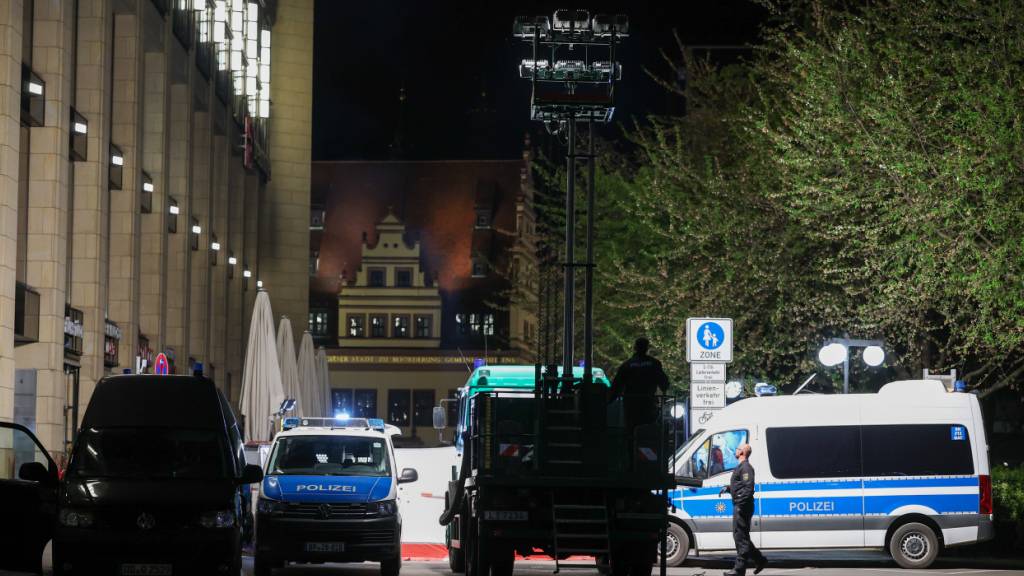 Polizisten errichten einen Lichtmast neben dem Sichtschutz vor dem Tatfahrzeug in der Grimmaischen Straße. In Leipzig ist ein Auto in mehrere Menschen gefahren. Nach Angaben der Polizei gibt es mehrere Verletzte. Foto: Jan Woitas/dpa