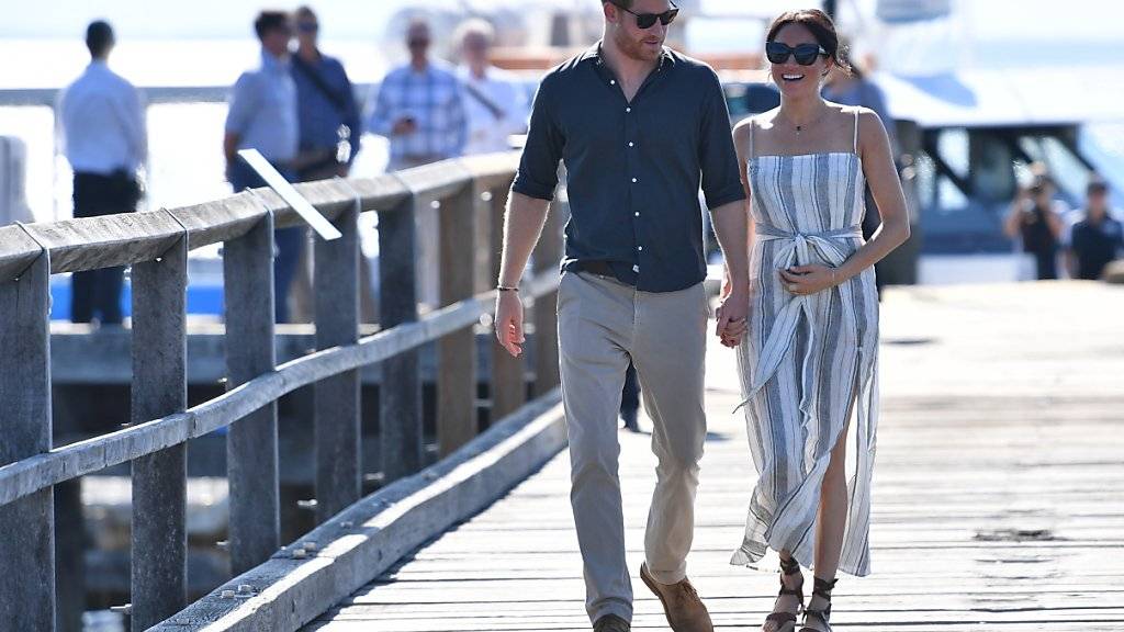 Entspannt spazieren Prinz Harry und seine Frau Meghan über eine Mole auf Fraser Island zu einem Treffen mit Fans.