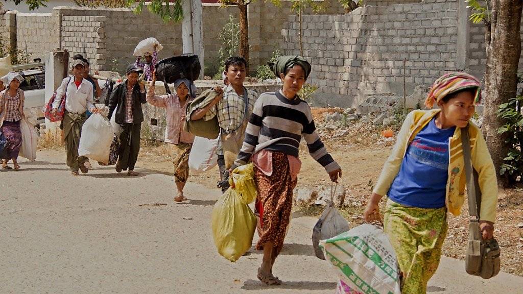 Fliehende tragen ihre Habseligkeiten aus der umkämpften Stadt Laukkai im Nordosten Myanmars.