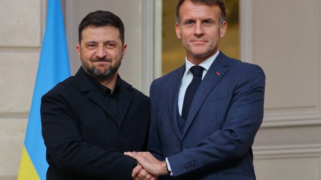 ARCHIV - Der ukrainische Präsident Wolodymyr Selenskyj (l) und der französische Präsident Emmanuel Macron geben sich nach einer gemeinsamen Pressekonferenz im Élysée-Palast die Hand. Foto: Sarah Meyssonnier/Pool Reuters via AP/dpa