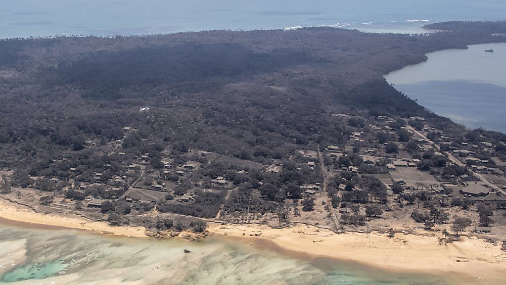 A supplied image shows the view from a P-3K2 Orion aircraft flying over an area of Tonga with ash on the roofs of homes and surrounding vegetation, Monday, January 17, 2022. (AAP Image/Supplied by NZDF, Vanessa Parker) NO ARCHIVING, EDITORIAL USE ONLY