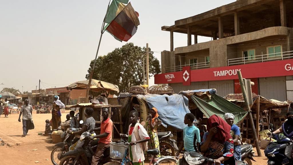 ARCHIV - Menschen stehen auf der Straße eines Vororts der burkinischen Hauptstadt Ouagadougou. Foto: Christina Peters/dpa-Zentralbild/dpa