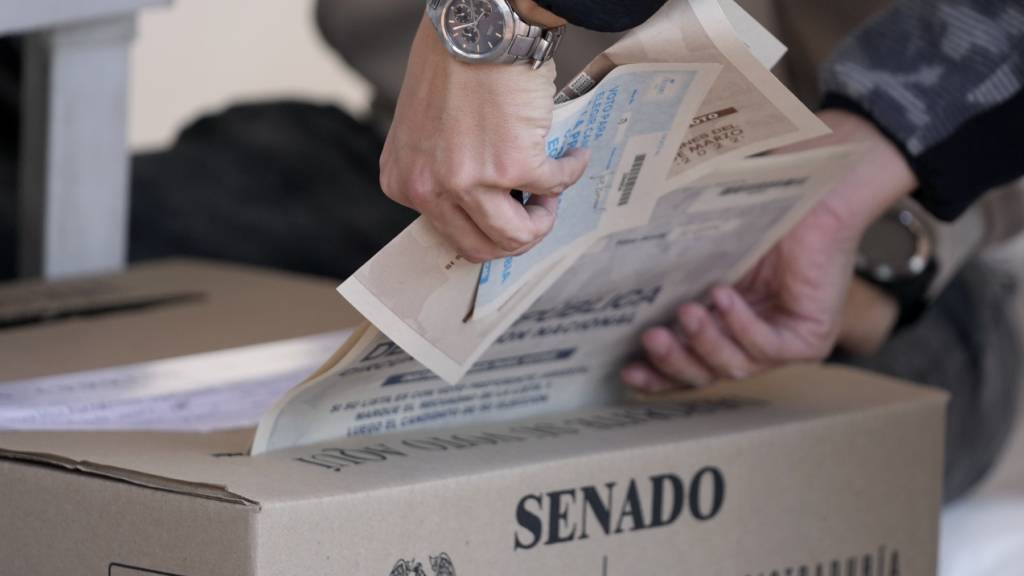 ARCHIV - Ein Mann gibt während der Parlamentswahl seinen Stimmzettel ab. In Kolumbien hat die Parlamentswahl begonnen. Foto: Fernando Vergara/AP/dpa